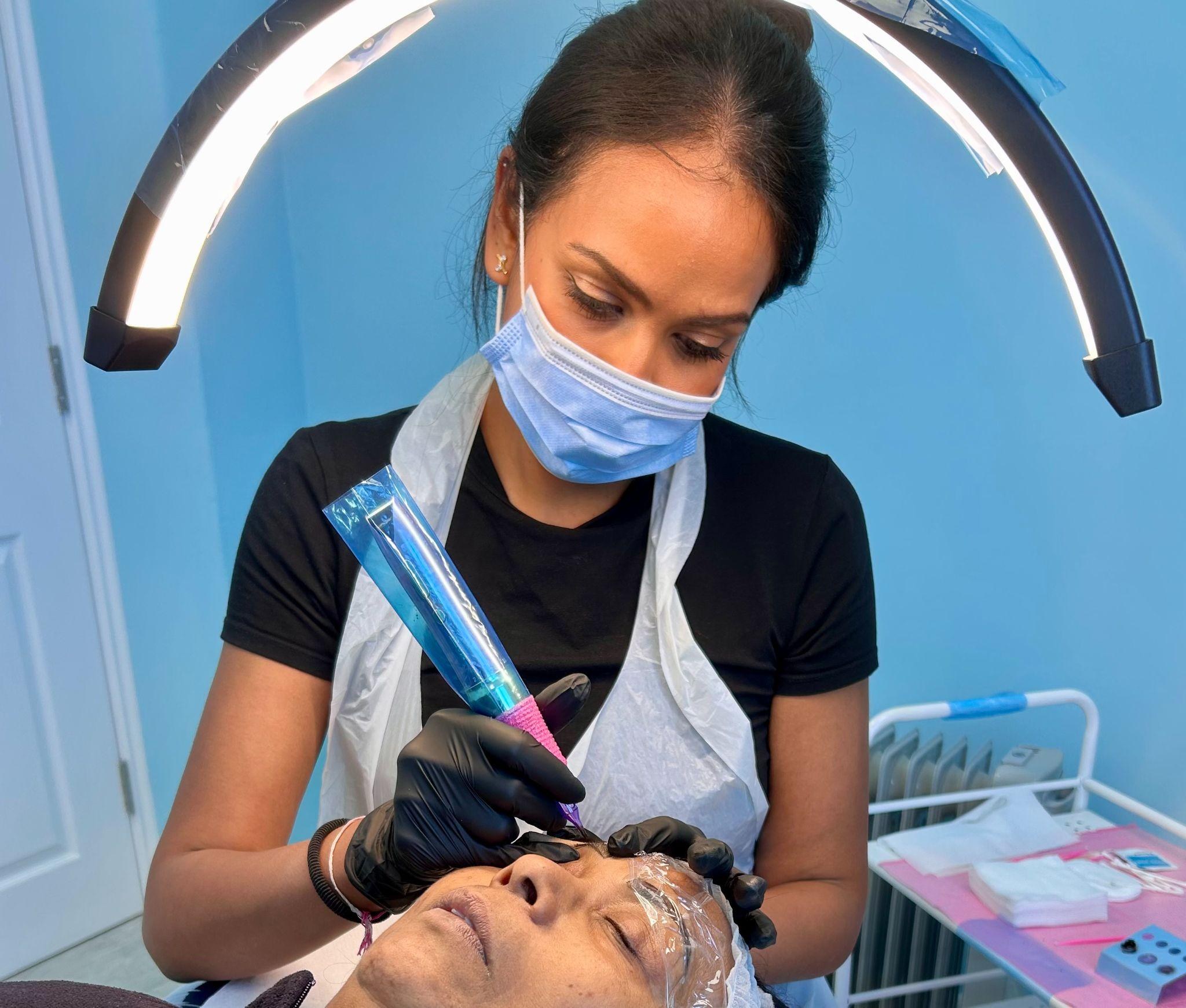Krishna performing a permanent makeup brow treatment in the studio